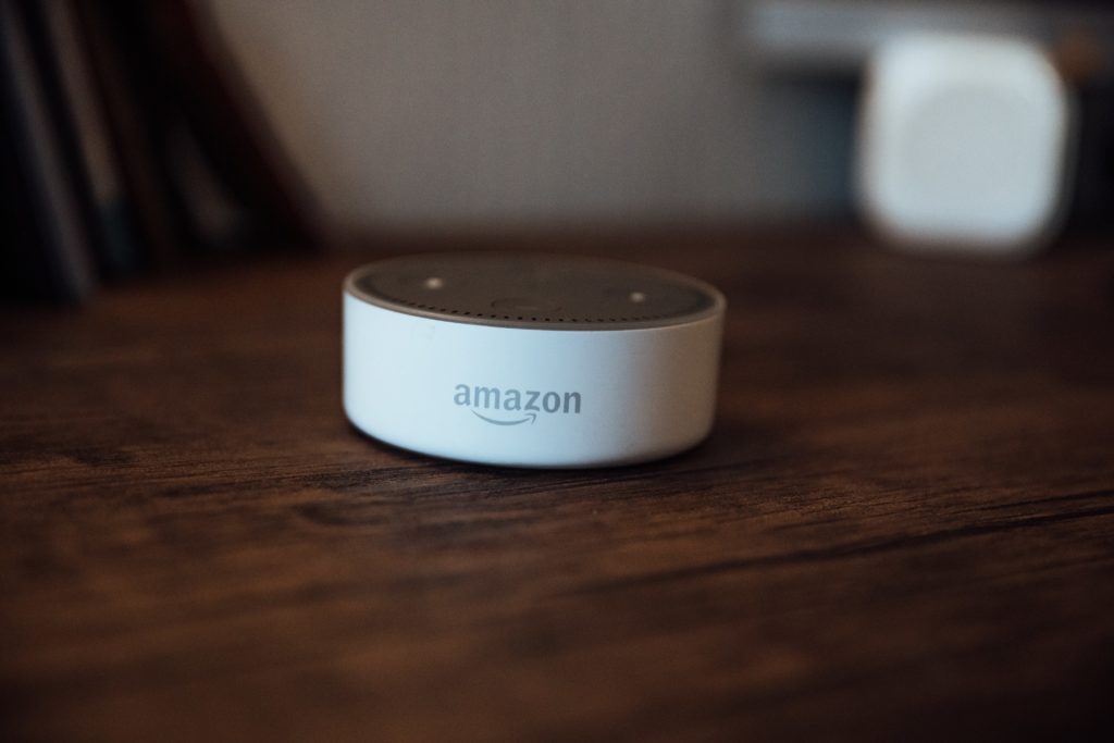 An Amazon smart speaker on a wooden coffee table